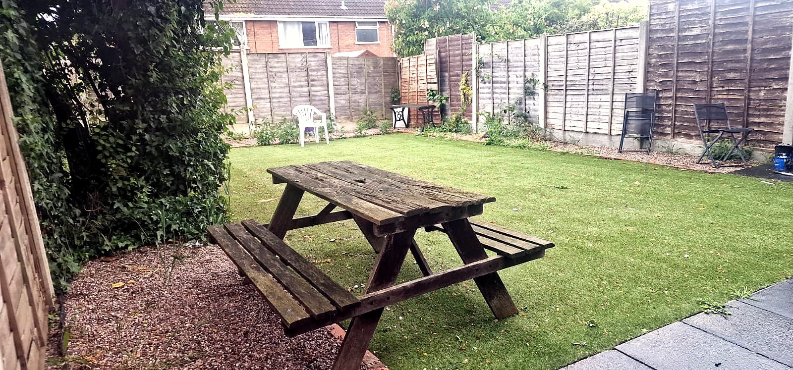 A private rear garden with lawn and picnic bench