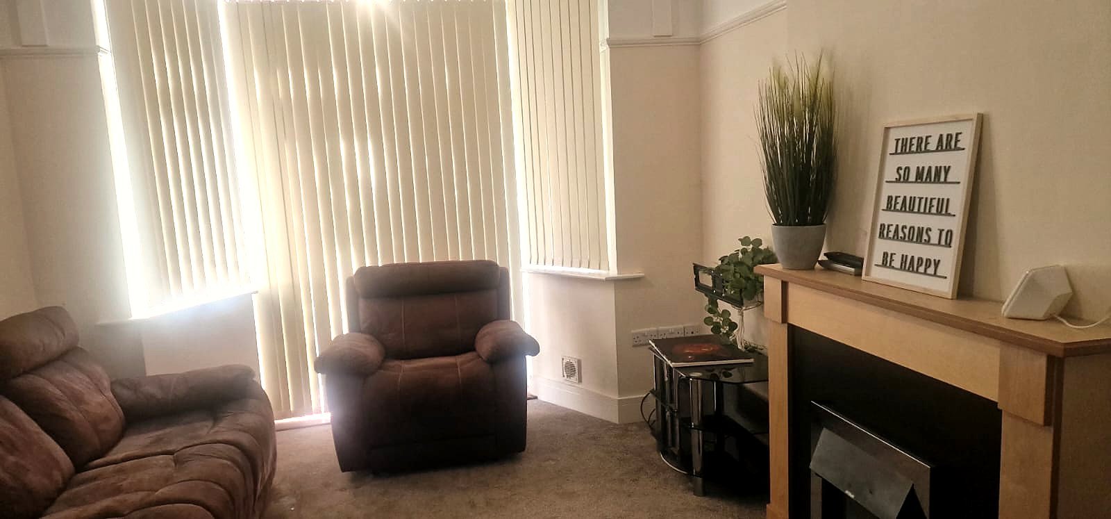 A bright lounge with a bay window, sofas and a fireplace